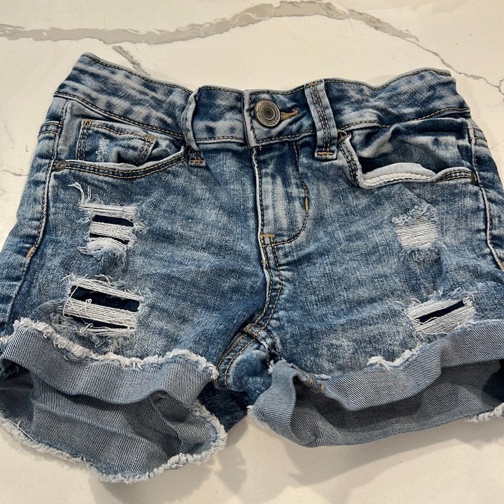 Girls stonewashed ripped jean shorts.